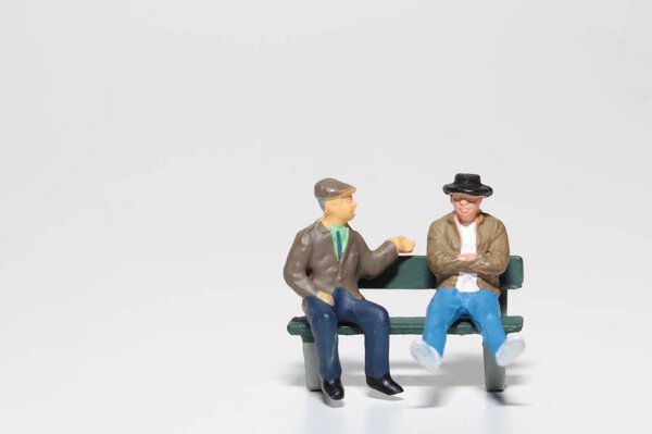 miniature people talking on a bench