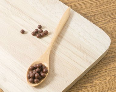 Üzerinde kahverengi bir tahta kaşık bitkisel öksürük pastil