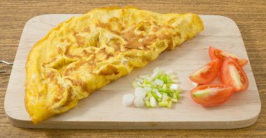 Domates ve yeşil soğan kesme tahtası üzerinde Tay omlet