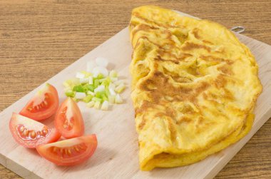 Domates ve yeşil soğan kesme tahtası üzerinde Tay omlet