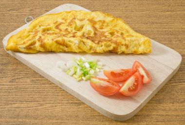 Domates ve yeşil soğan ahşap tahta üzerinde Tay omlet