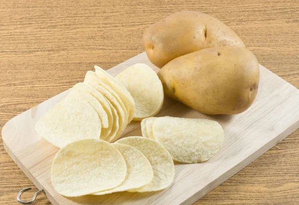 Patatas y patatas fritas en tablero de madera — Foto de Stock