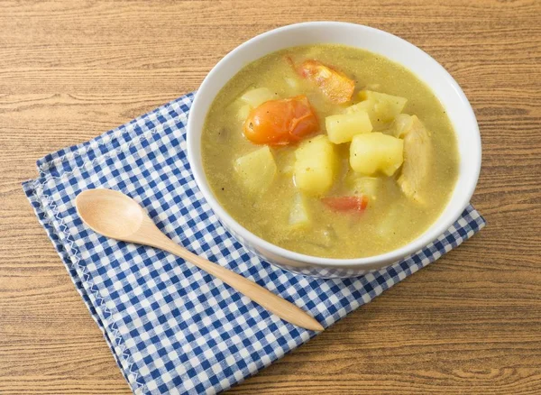 Bowl of Curry Soup with Potato and Tomato