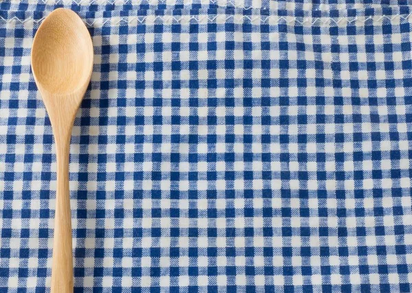 Cuchara de madera marrón en patrón de servilleta de cuadros azules — Foto de Stock