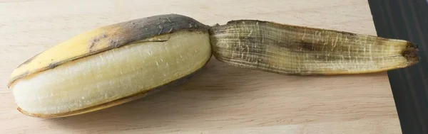 Fruta de banana madura aberta na mesa de madeira — Fotografia de Stock