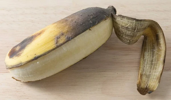 Fruta de banana velha aberta na mesa de madeira — Fotografia de Stock