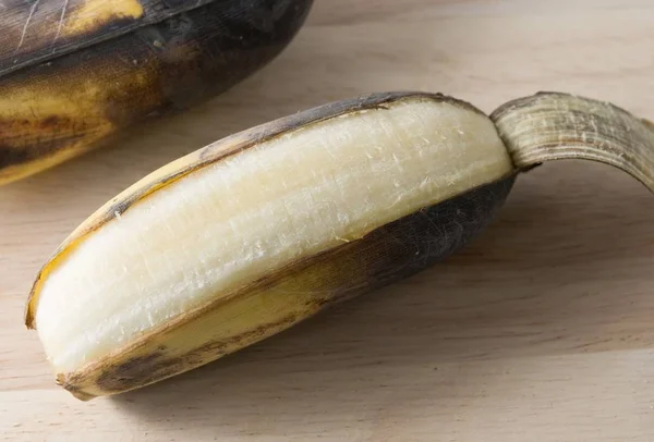 Abrir fruta vieja de plátano en una tabla de madera —  Fotos de Stock