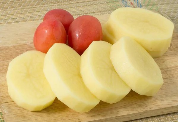 木板上的新鲜土豆和番茄 — 图库照片