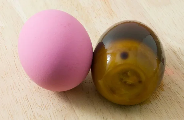 Два яйца розового века на деревянной доске — стоковое фото