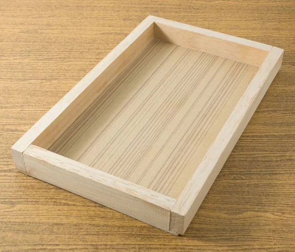 Κενό ξύλινο δίσκο ορθογώνιο σε έναν πίνακα — Φωτογραφία Αρχείου