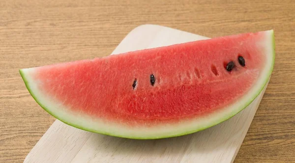 Skivad mogen vattenmelon på en träskiva — Stockfoto