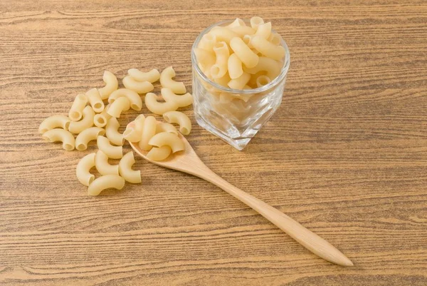 Gomiti Macarrones de pasta o codo sobre mesa de madera — Foto de Stock