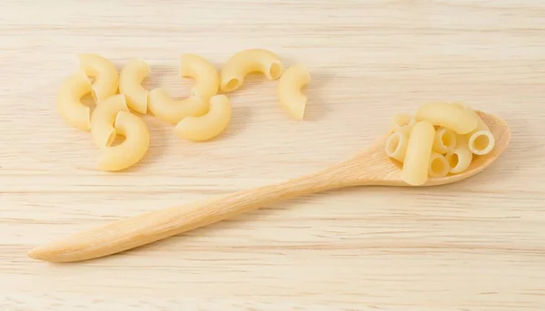 Gomiti o maccheroni gomiti in cucchiaio di legno — Foto Stock