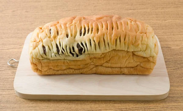 Pan de pasas en tabla de cortar de madera — Foto de Stock