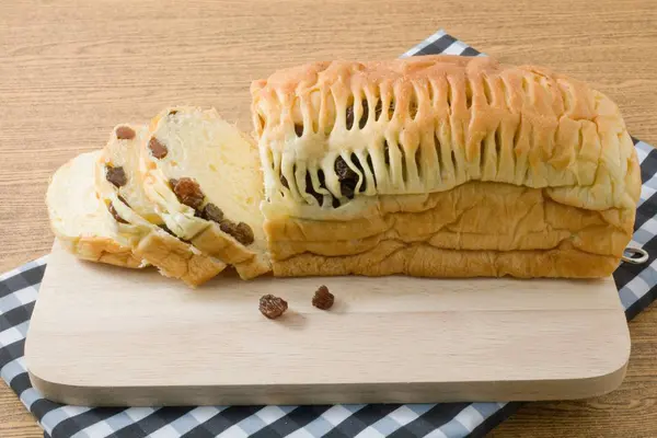 Pane affettato di pane di uva passa su un tagliere di legno — Foto Stock