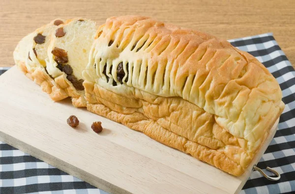 Pão Raisin fatiado em uma placa de corte de madeira — Fotografia de Stock