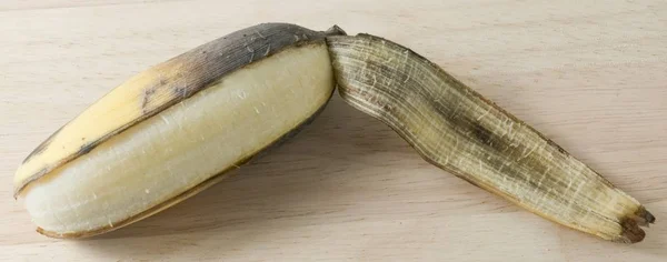 Fruta de banana madura aberta na mesa de madeira — Fotografia de Stock