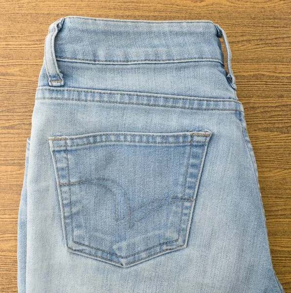 Niebieskie jeansy na drewnianym stole — Zdjęcie stockowe
