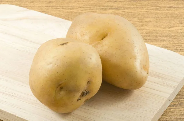 Bulwy ziemniaków organicznych na drewnianą deską do krojenia — Zdjęcie stockowe