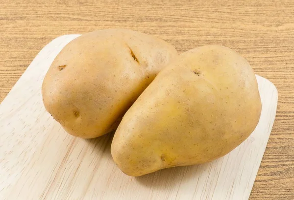 Ekologisk potatis Tuber på en skärbräda — Stockfoto