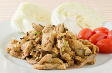 Beyaz bir tabak salataya baharatlı ızgara domuz