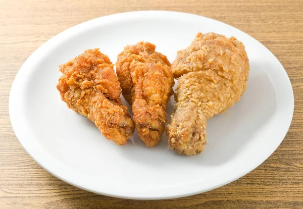 Alas de pollo frito en un plato blanco —  Fotos de Stock
