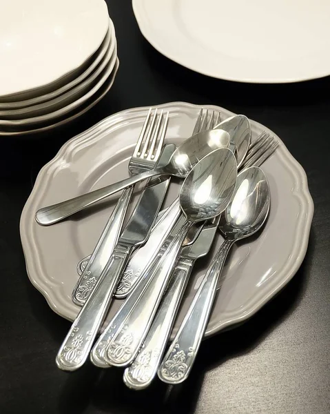 Porcelán tányérok, edények, evőeszköz készlet — Stock Fotó