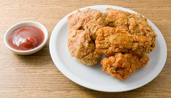 Frango frito com molho em um prato branco — Fotografia de Stock