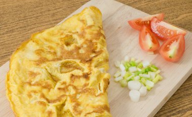 Domates ve yeşil soğan kesme tahtası üzerinde Tay omlet