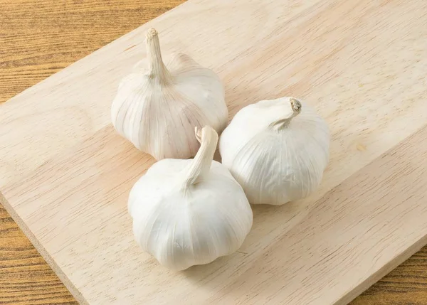 Bovenaanzicht van de bollen knoflook op een houten snijplank — Stockfoto