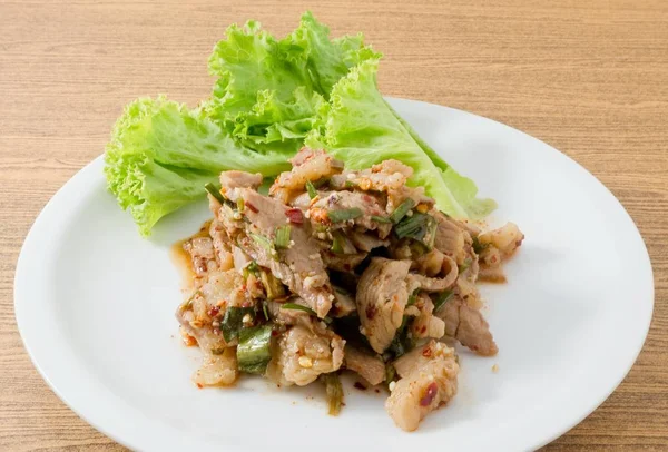 Тарелка острого салата из говядины на деревянном столе — стоковое фото