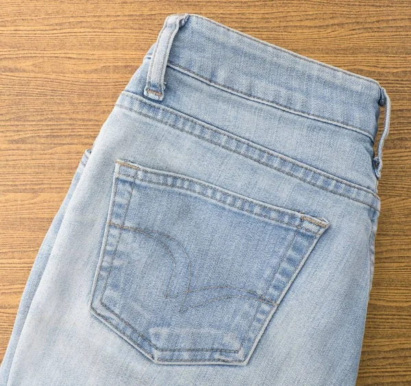 Niebieskie jeansy na drewnianym stole — Zdjęcie stockowe