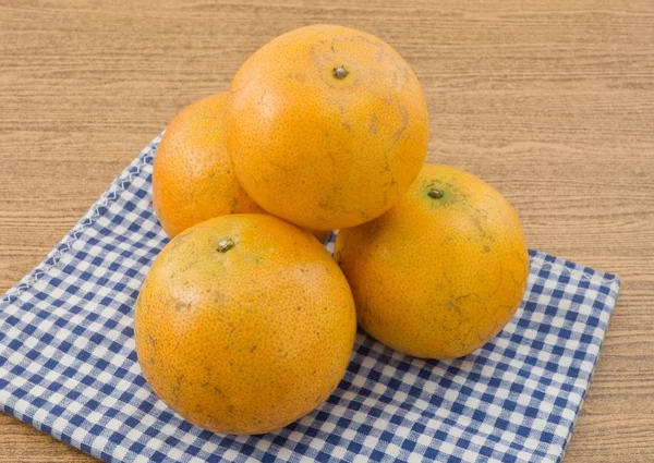 Cuatro naranjas maduras en una mesa de madera —  Fotos de Stock