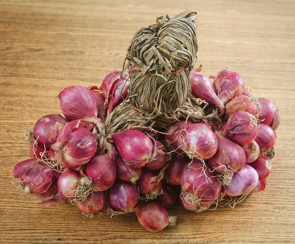 Bouquet d'oignons rouges frais sur table en bois — Photo