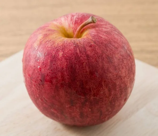 Primer plano manzana roja en tablero de corte de madera —  Fotos de Stock