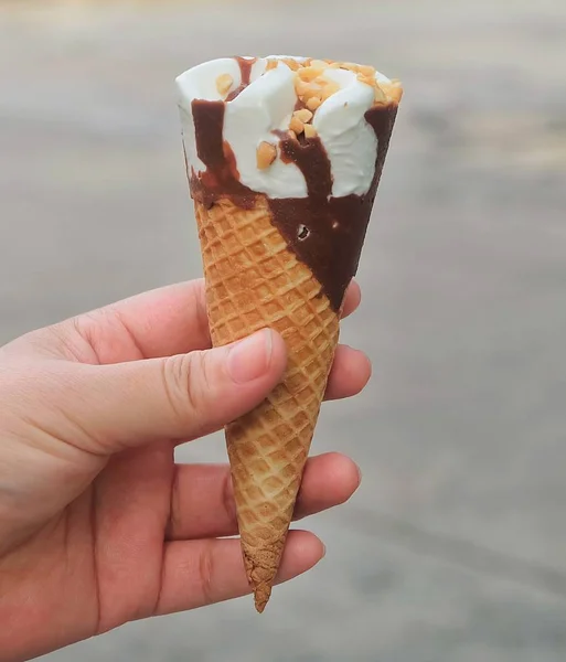 Hand hält Eiszapfen mit Schokolade — Stockfoto