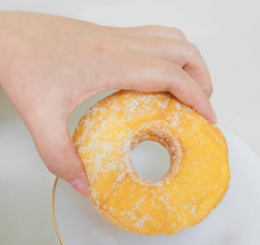 Şeker ile lezzetli sırlı Donut tutan el