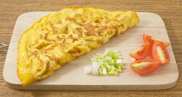 Domates ve yeşil soğan kesme tahtası üzerinde Tay omlet