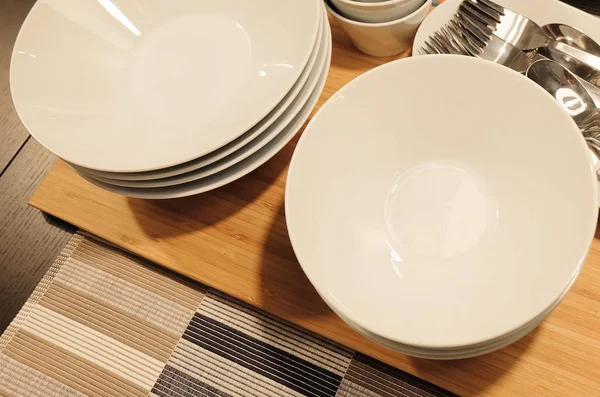 Porcelán tányérok, edények, evőeszköz készlet — Stock Fotó