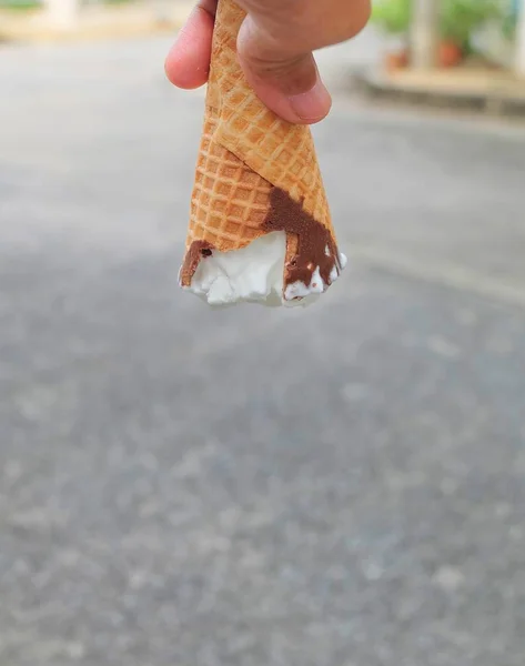 Ręka trzyma szyszki lodów z czekoladą — Zdjęcie stockowe