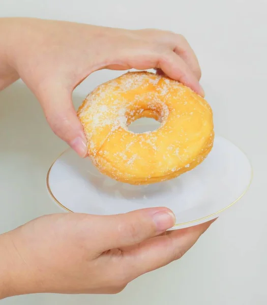 Mano celebración delicioso esmaltado donut con azúcar — Foto de Stock