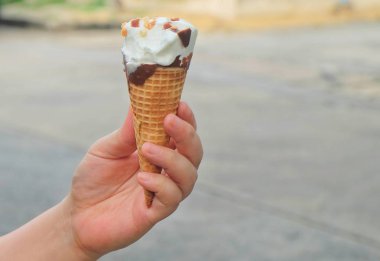 Çikolatalı dondurma koni tutan el