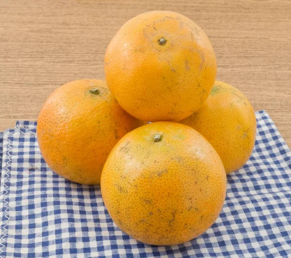 Cuatro naranjas maduras en una mesa de madera —  Fotos de Stock