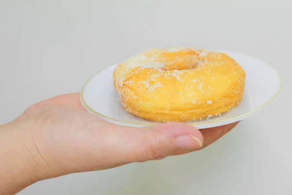 Hand hält köstlichen glasierten Donut mit Zucker — Stockfoto