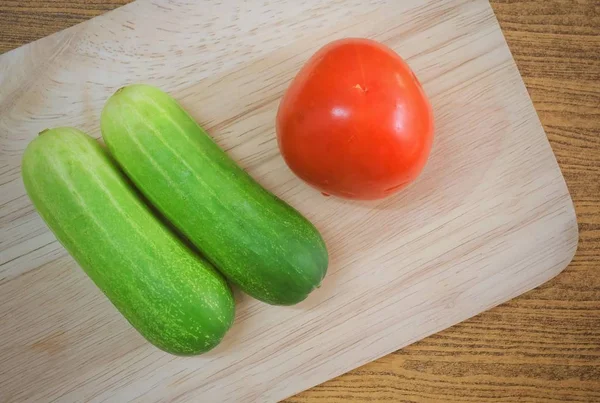 Verse tomaat met komkommers op snijplank — Stockfoto