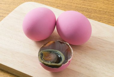 Bir kesme tahtası üzerinde pembe yüzyıl yumurta