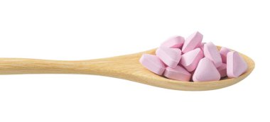 Tahta kaşık beyaz üzerine pembe vitamin dolu