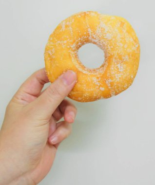 Şeker ile lezzetli sırlı Donut tutan el
