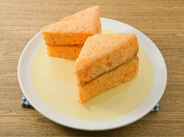 2 つの三角形、皿の上のオレンジのシフォン ケーキ — ストック写真