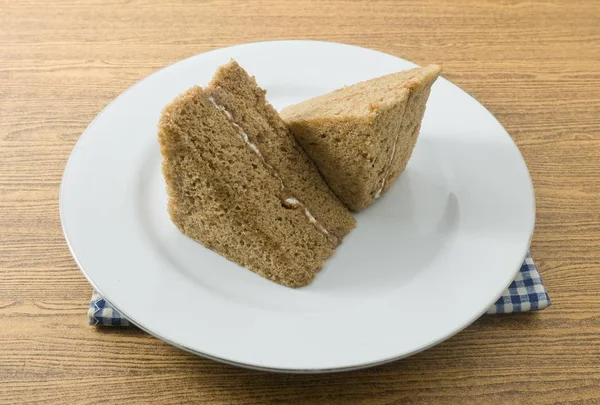 軽食やデザート コーヒーのシフォン ケーキは バター 小麦粉 ベーキング パウダー 白い皿に調味料で作られた つのトライアングル — ストック写真